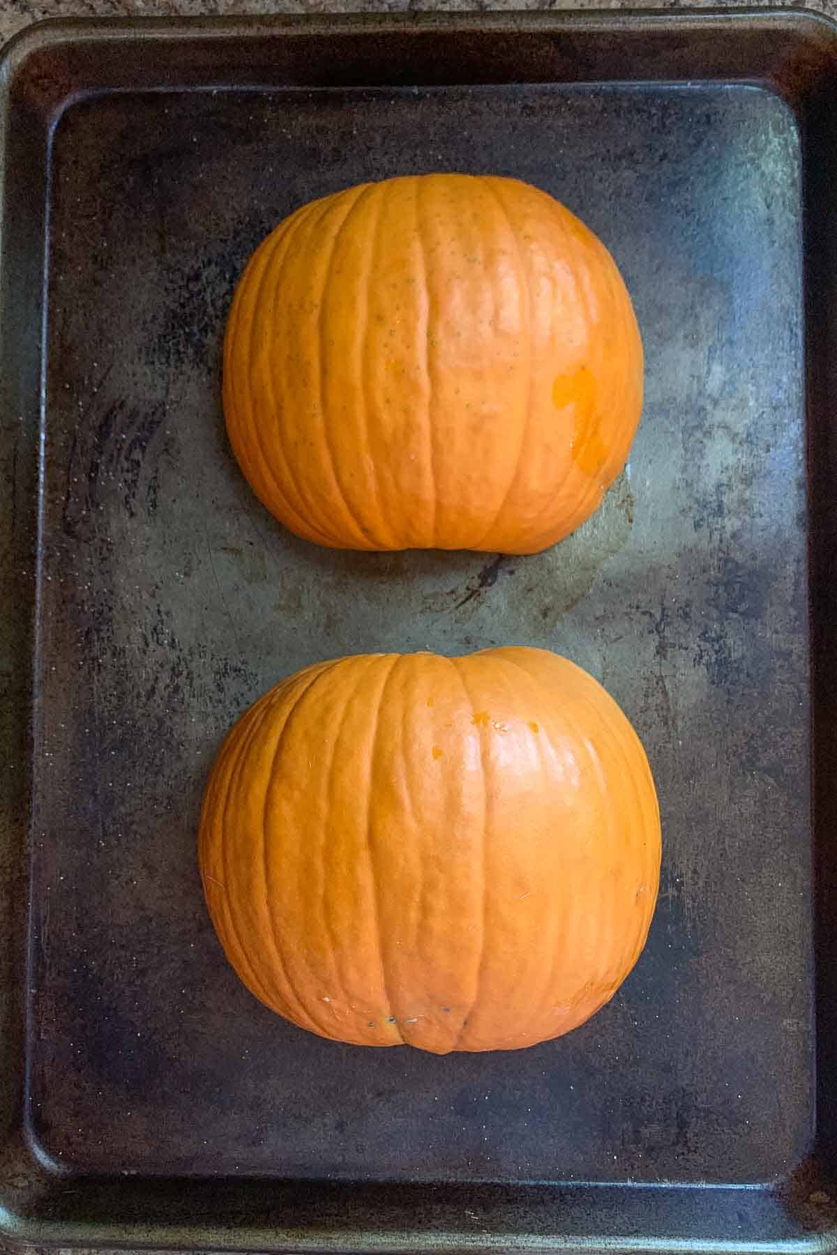 pumpkin halves on baking sheet