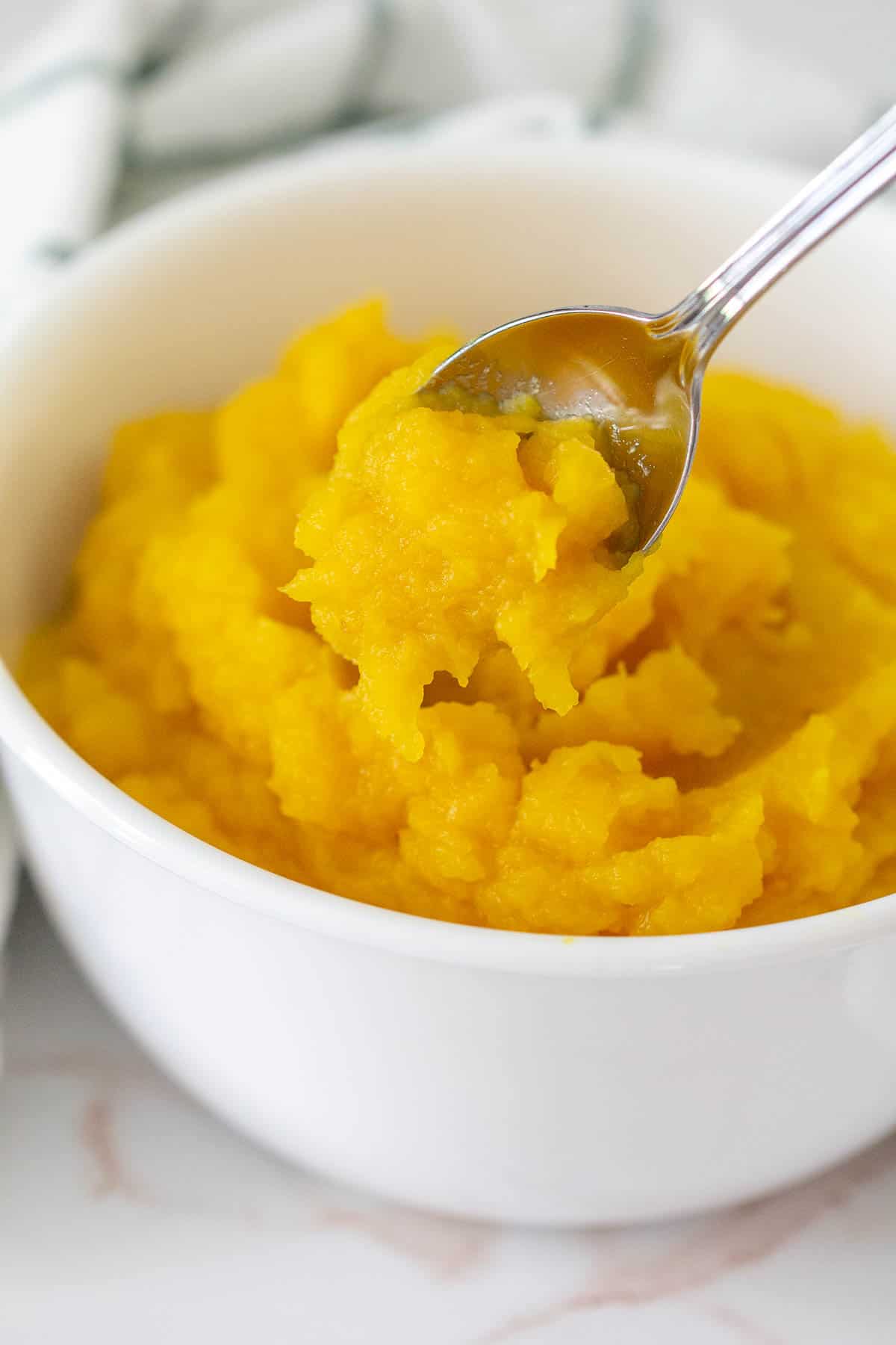 bowl of pumpkin puree with a spoon holding some out