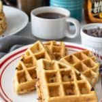 Plate of chocolate chip waffles cut into quarters.