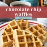 Four chocolate chip waffles are served on a white plate with a red rim. In the background, a coffee cup, syrup bottle, and blue sugar bowl set the scene. Text overlay reads "chocolate chip waffles" to highlight this classic breakfast treat.