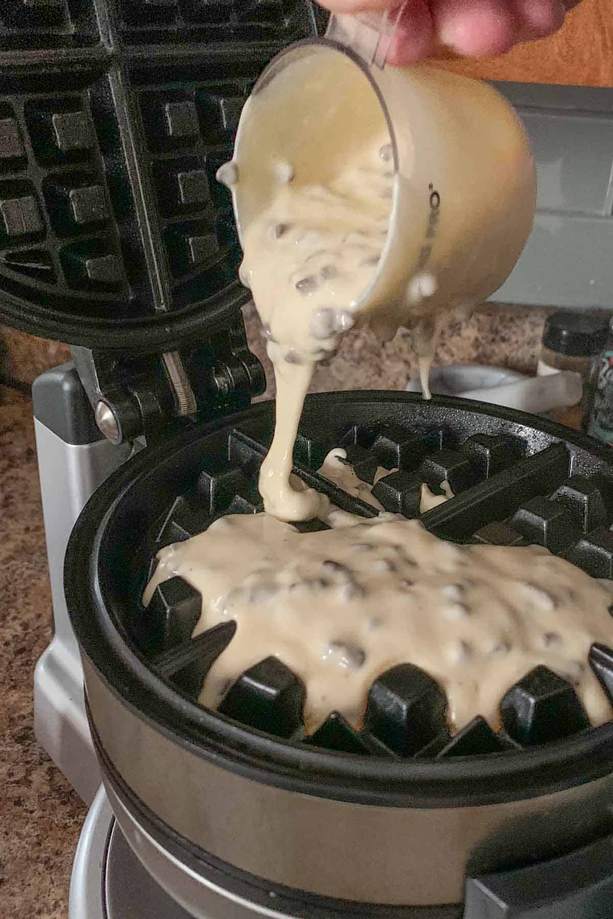 Pouring batter into waffle iron.