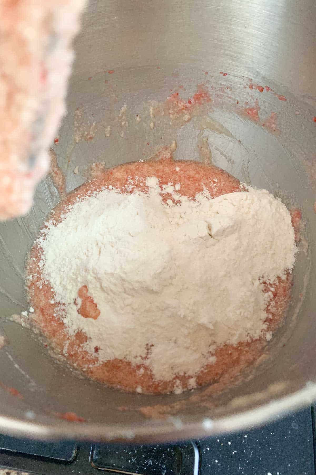 adding flour to strawberry cupcake batter