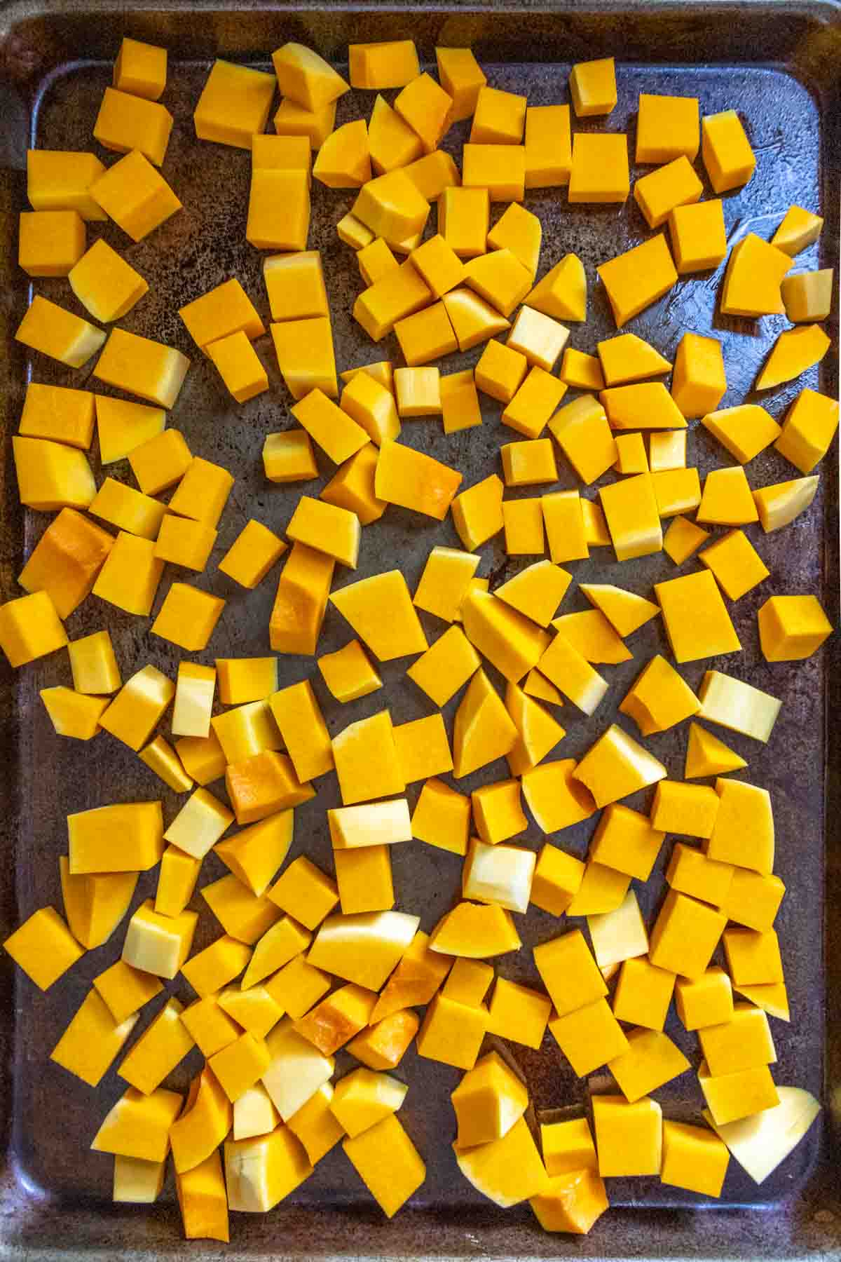 overhead of butternut squash cubes on baking sheet