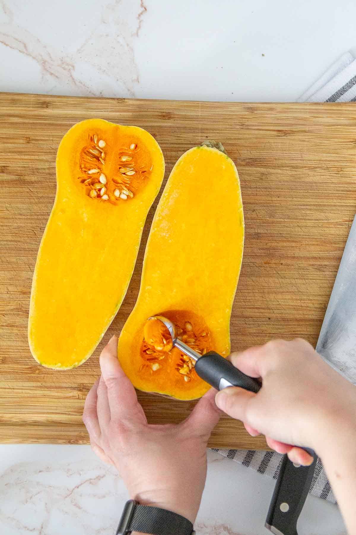 scooping seeds out of butternut squash