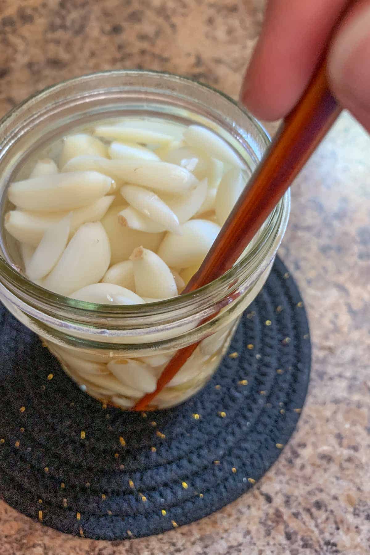 removing air bubbles in jar with chopstick