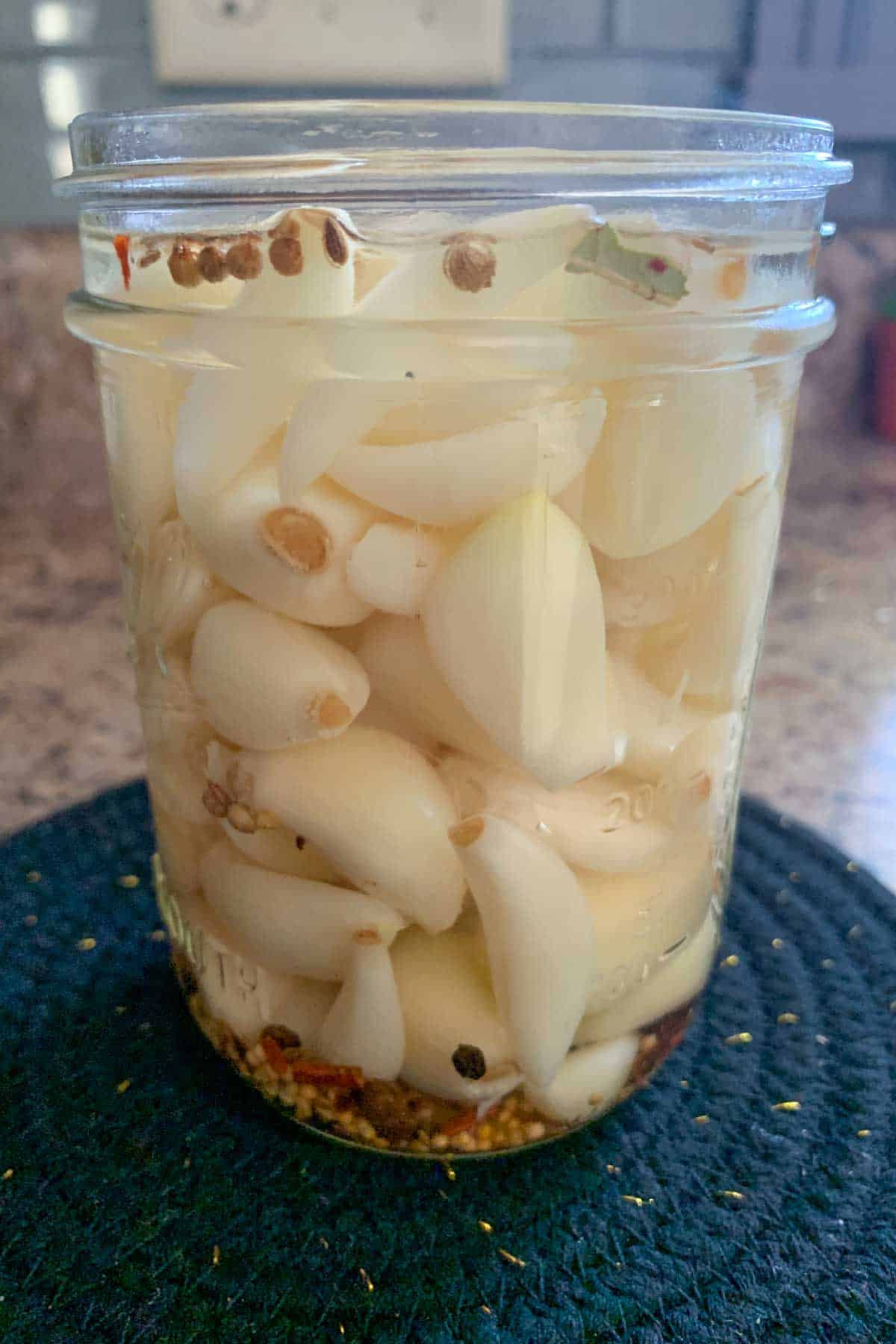 pickled garlic in glass jar showing fill line