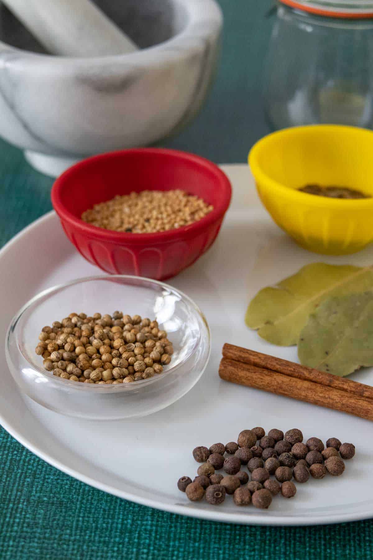 ingredients for pickling spice on a plate