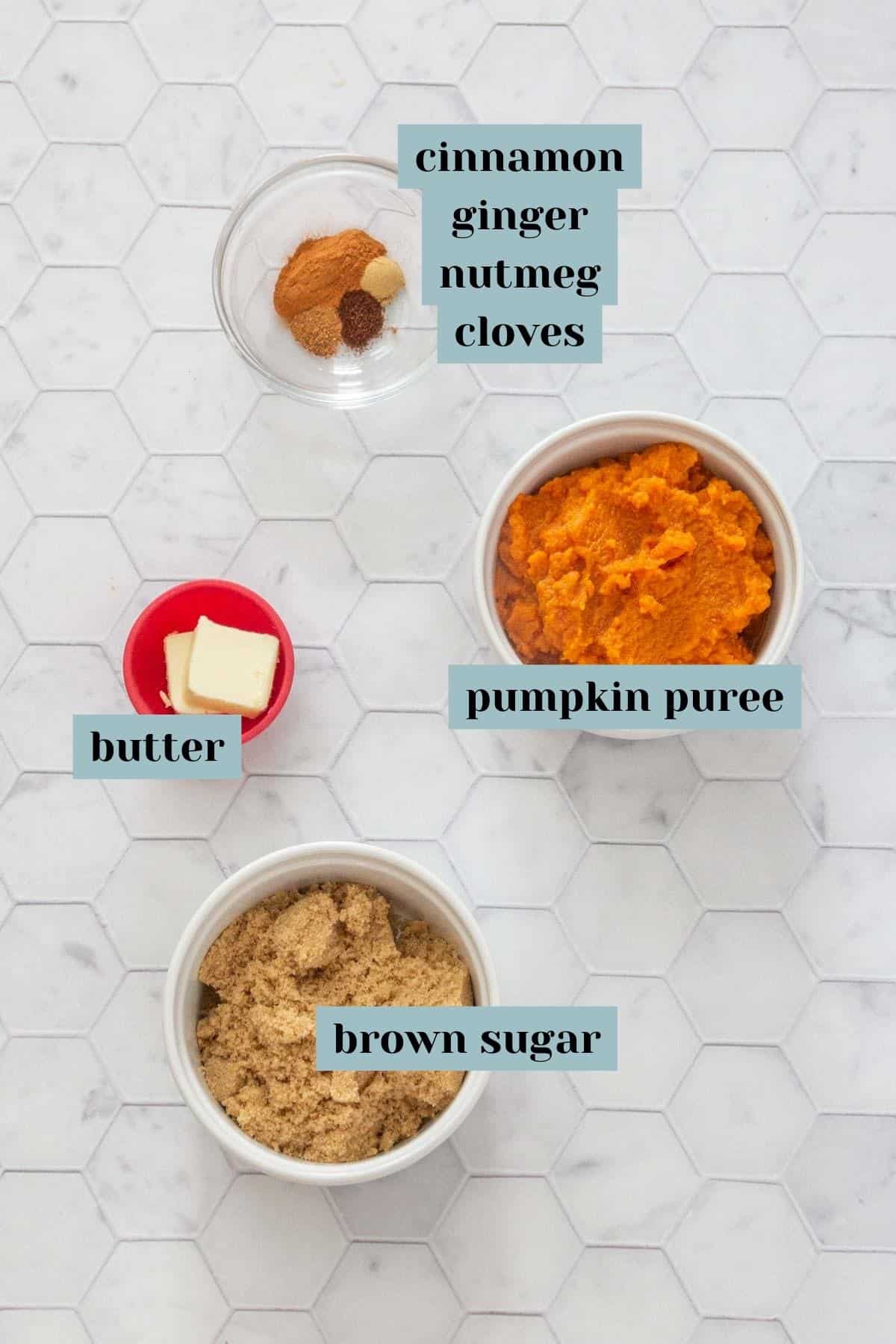 Ingredients for pumpkin empanada filling on a tile surface with labels.