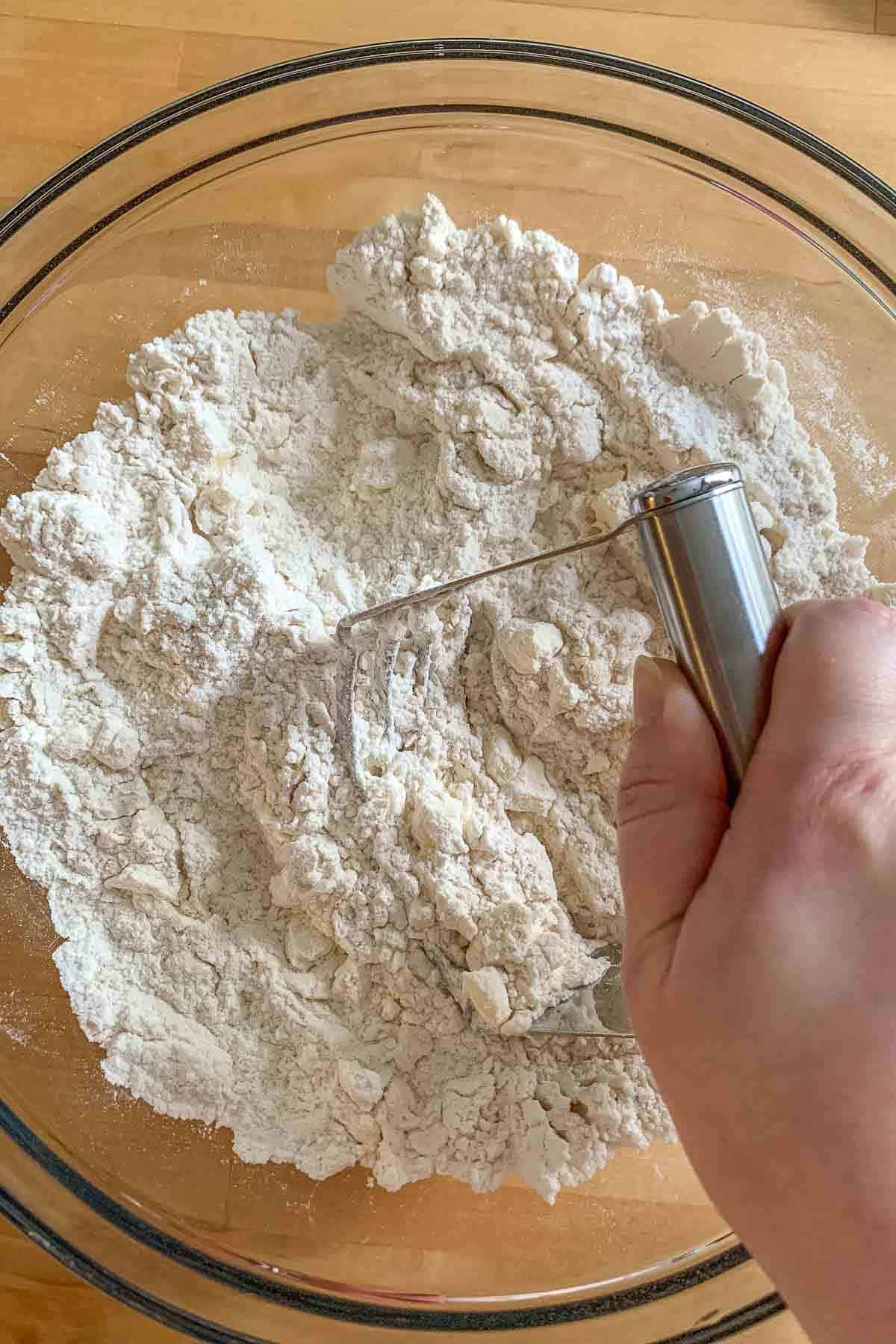 Cutting butter into pastry dough using a pastry blender.