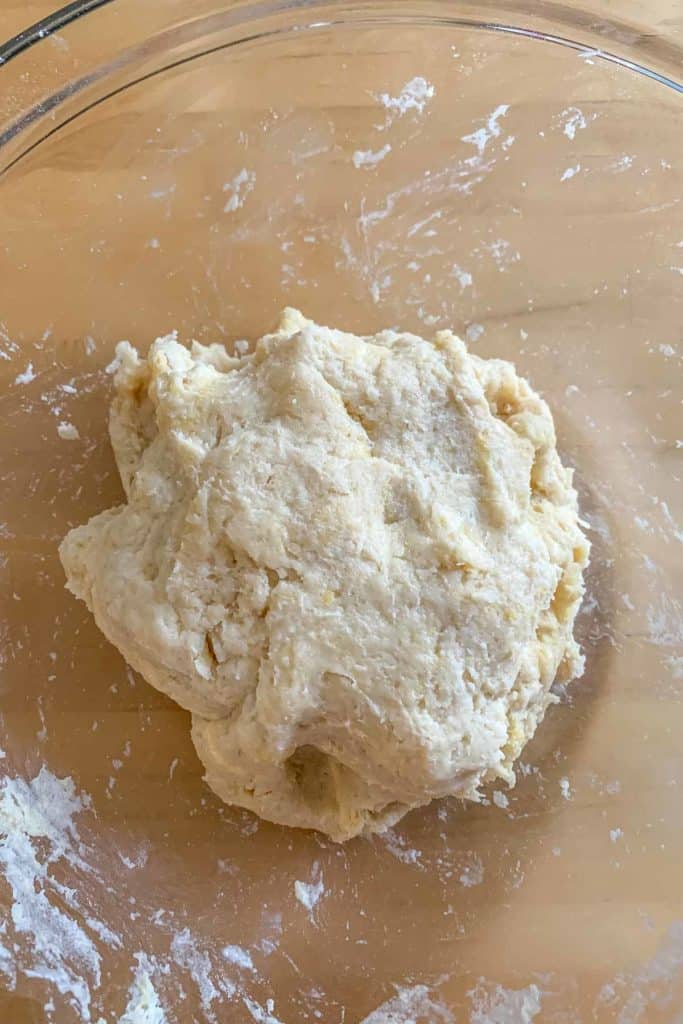 Mixed together empanada dough in a glass bowl.