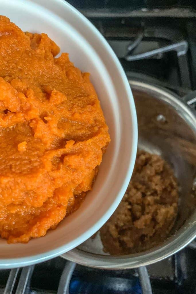 Adding pumpkin to brown sugar and butter for empanada filling.