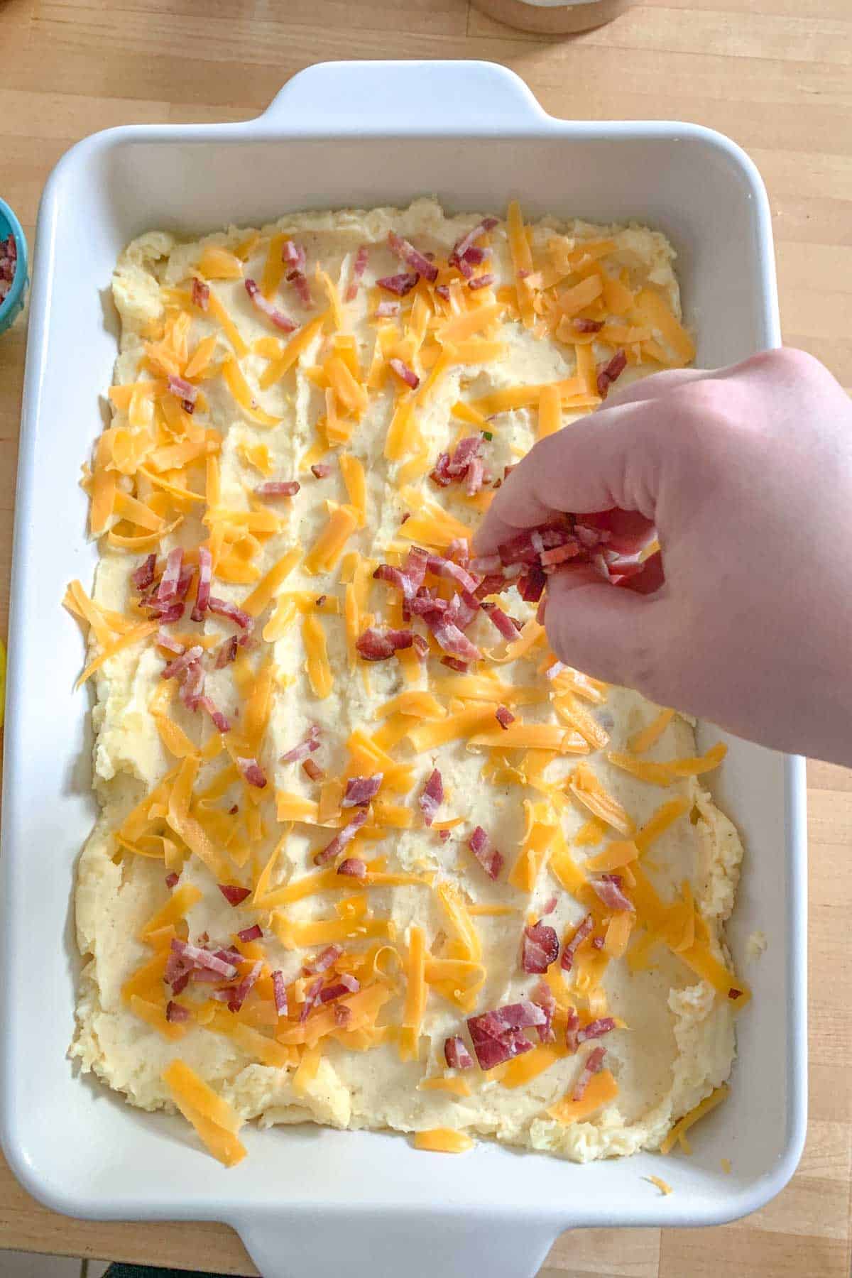 adding toppings to twice baked mashed potatoes