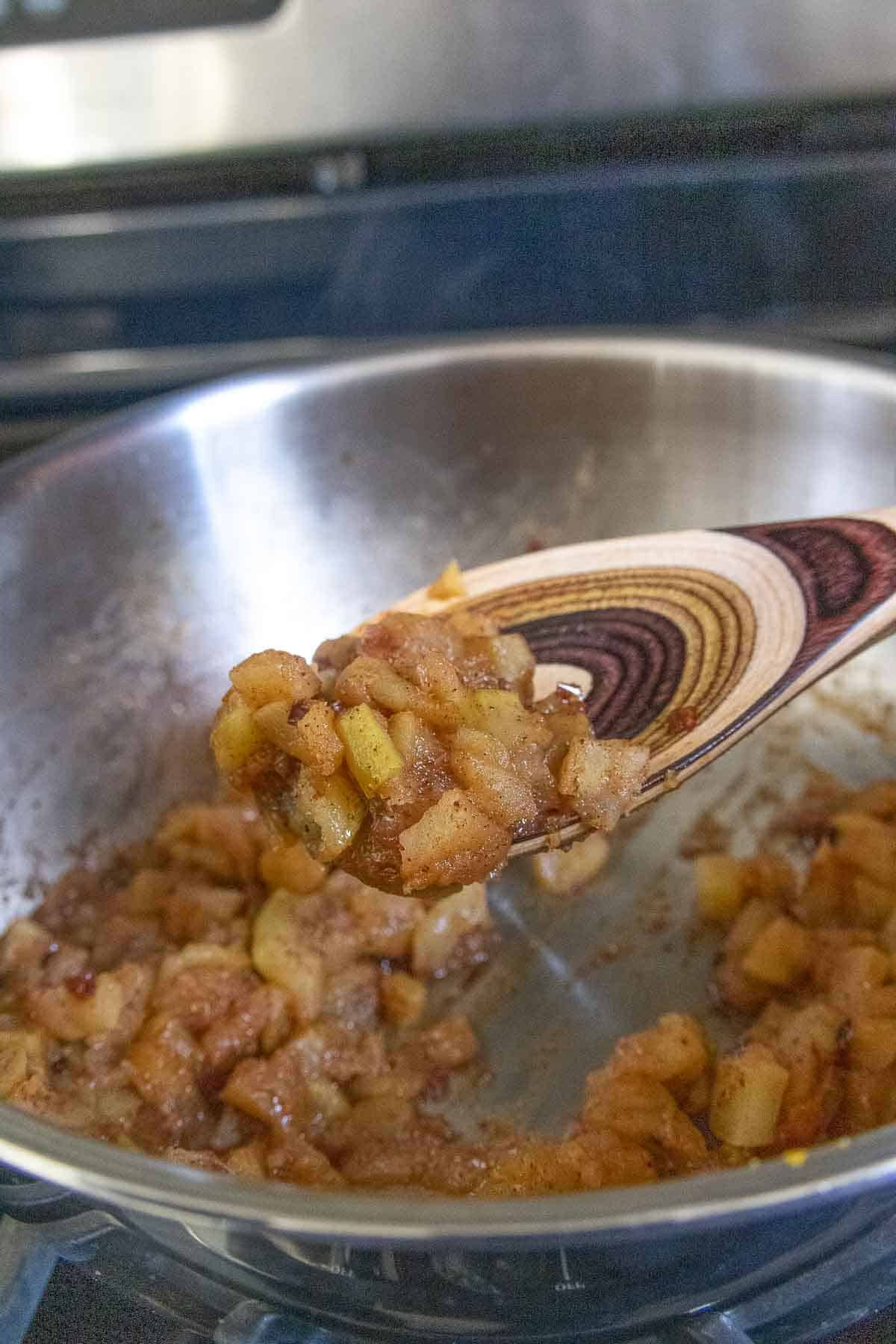 Spoonful of apple compote after cooking, above saute pan.