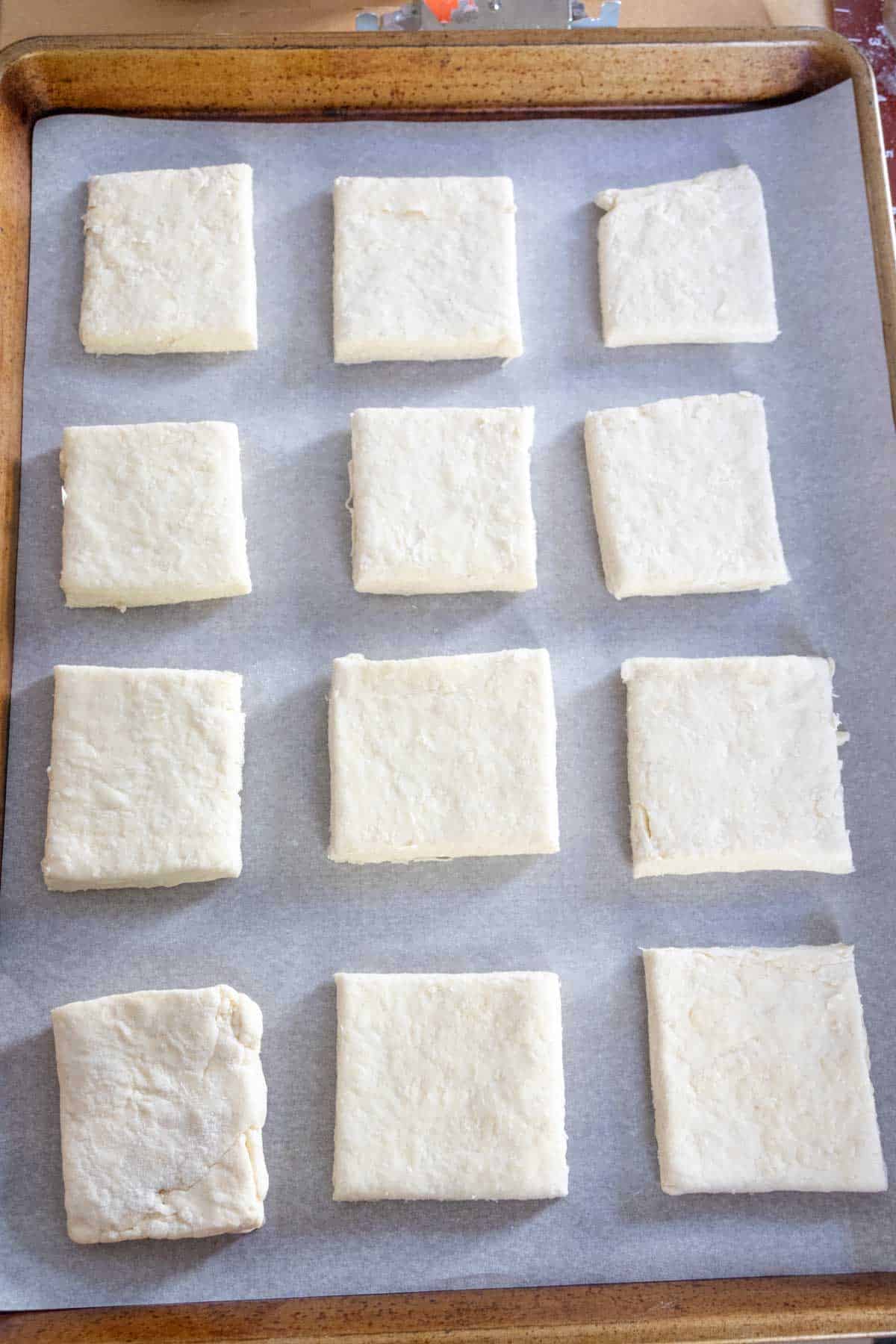 Unbaked biscuits on a sheet pan.