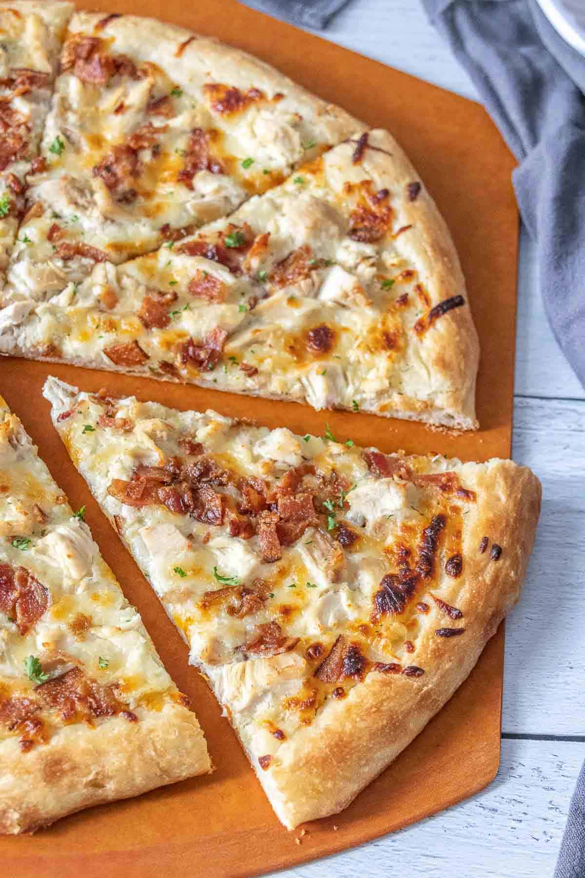 Chicken bacon ranch pizza with a slice being pulled away.