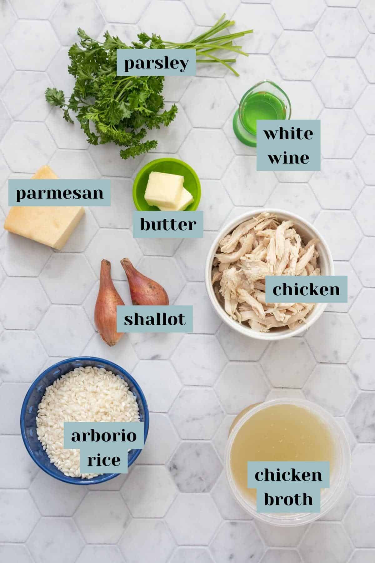 Ingredients for chicken risotto on a tile surface with labels.