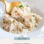A spoonful of creamy chicken risotto is held above a plate filled with more chicken risotto, beautifully garnished with chopped herbs.