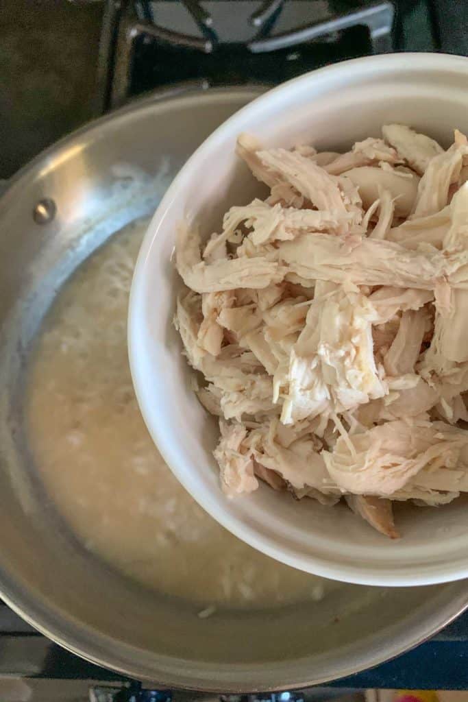 Adding chicken to risotto.