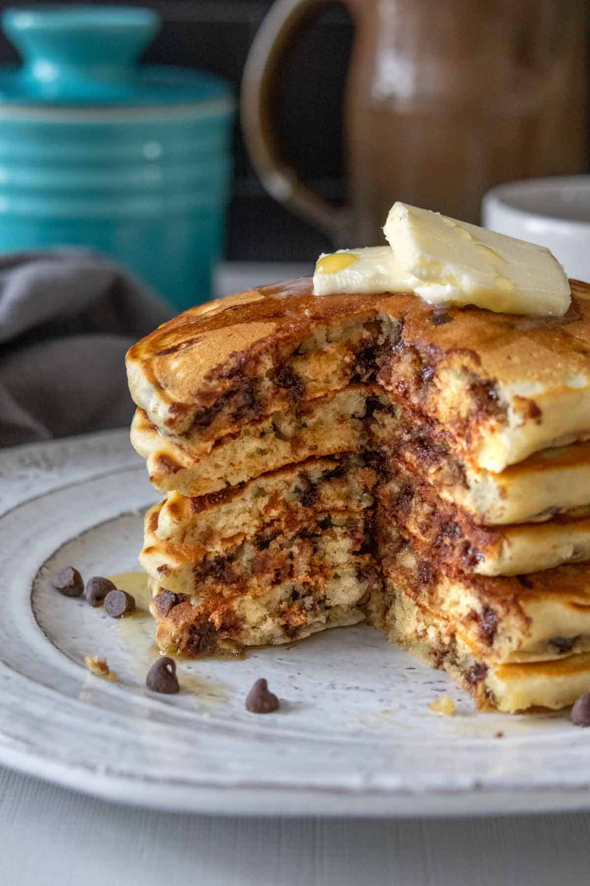 Stack of chocolate chip pancakes with a wedge cut out so the interior is seen.