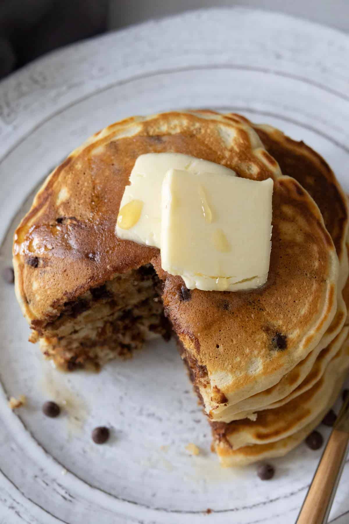 Stack of chocolate chip pancakes from above with a wedge cut out.