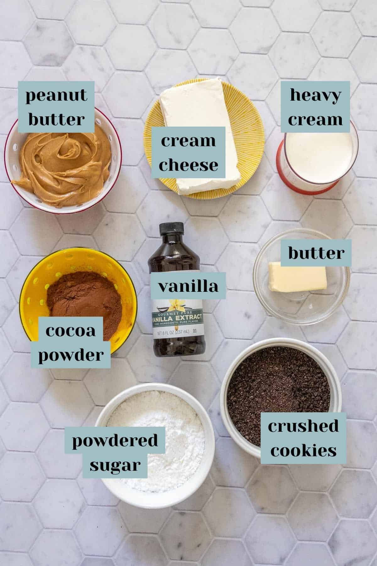 Ingredients for chocolate peanut butter pie on a tile surface with labels.