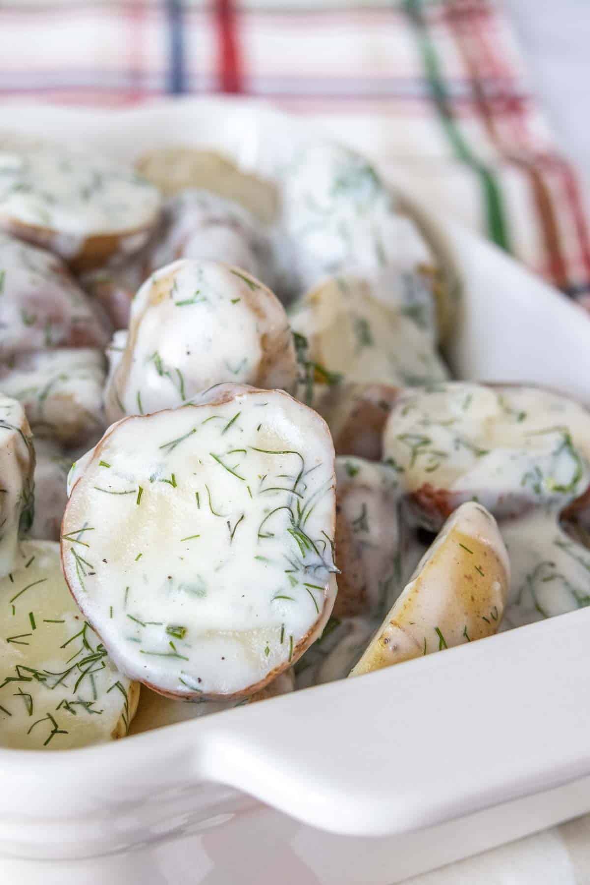 Dill potatoes in a white serving dish.