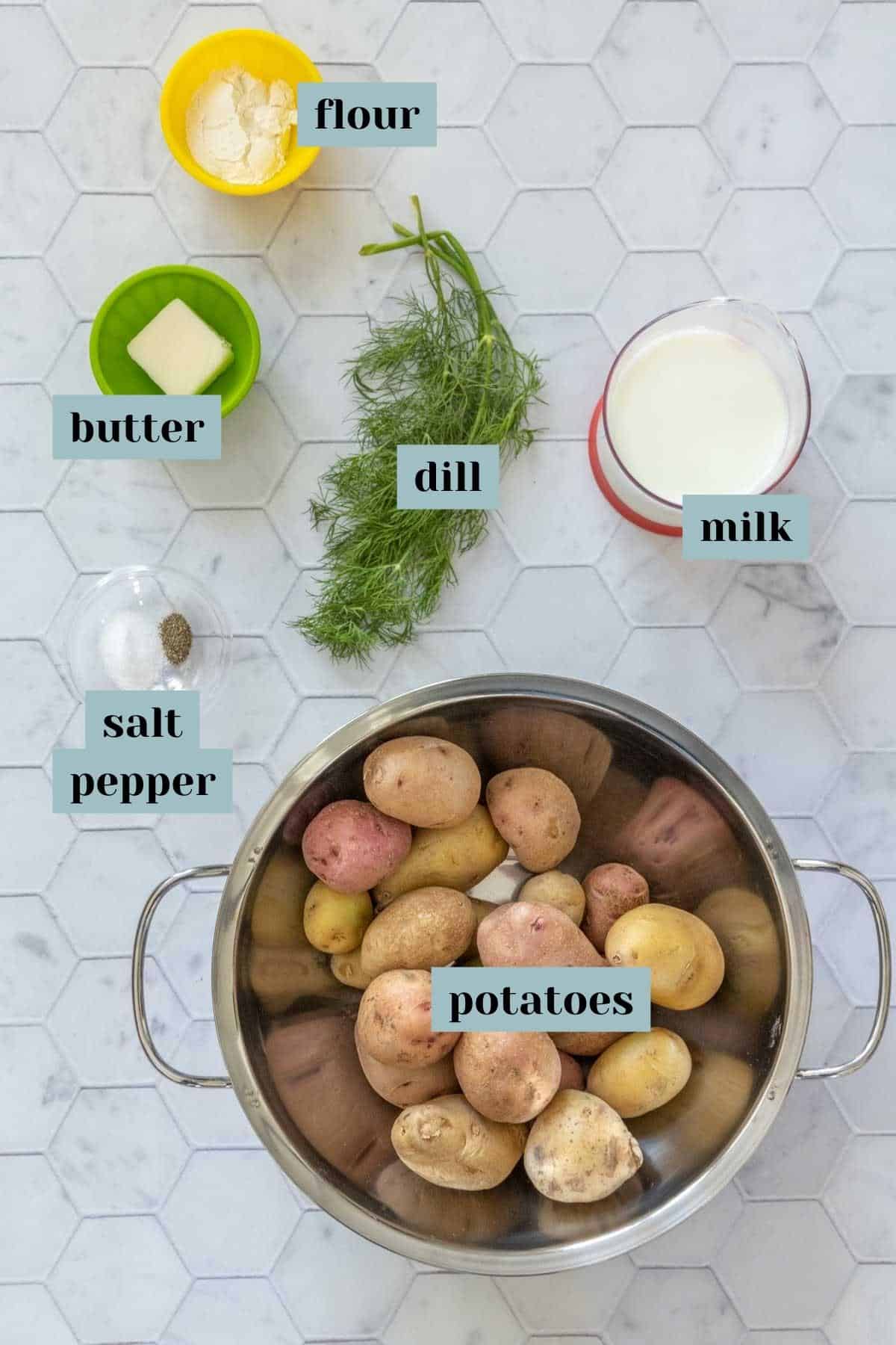 Ingredients for dill potatoes on a tile surface with labels.