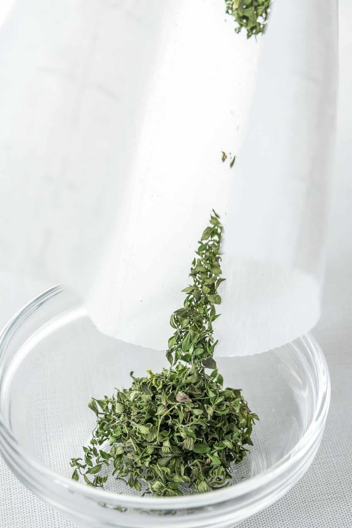 Pouring dried thyme into glass bowl.