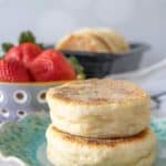 Two English muffins stacked on a blue plate.