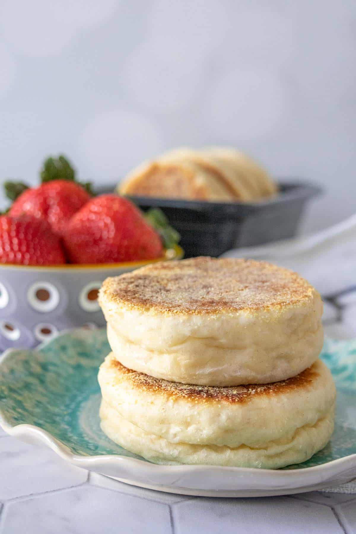 Two English muffins stacked on a blue plate.