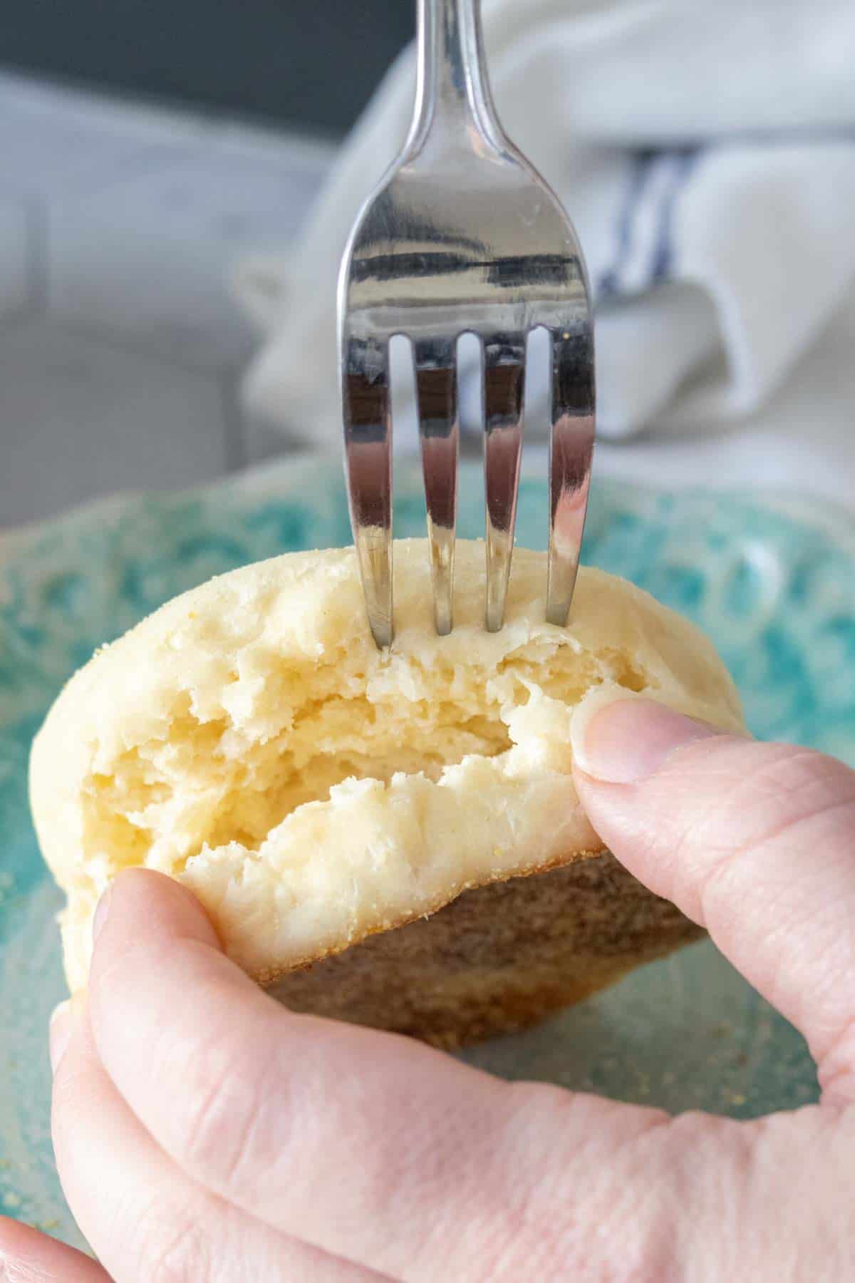Splitting apart an English muffin with a fork.