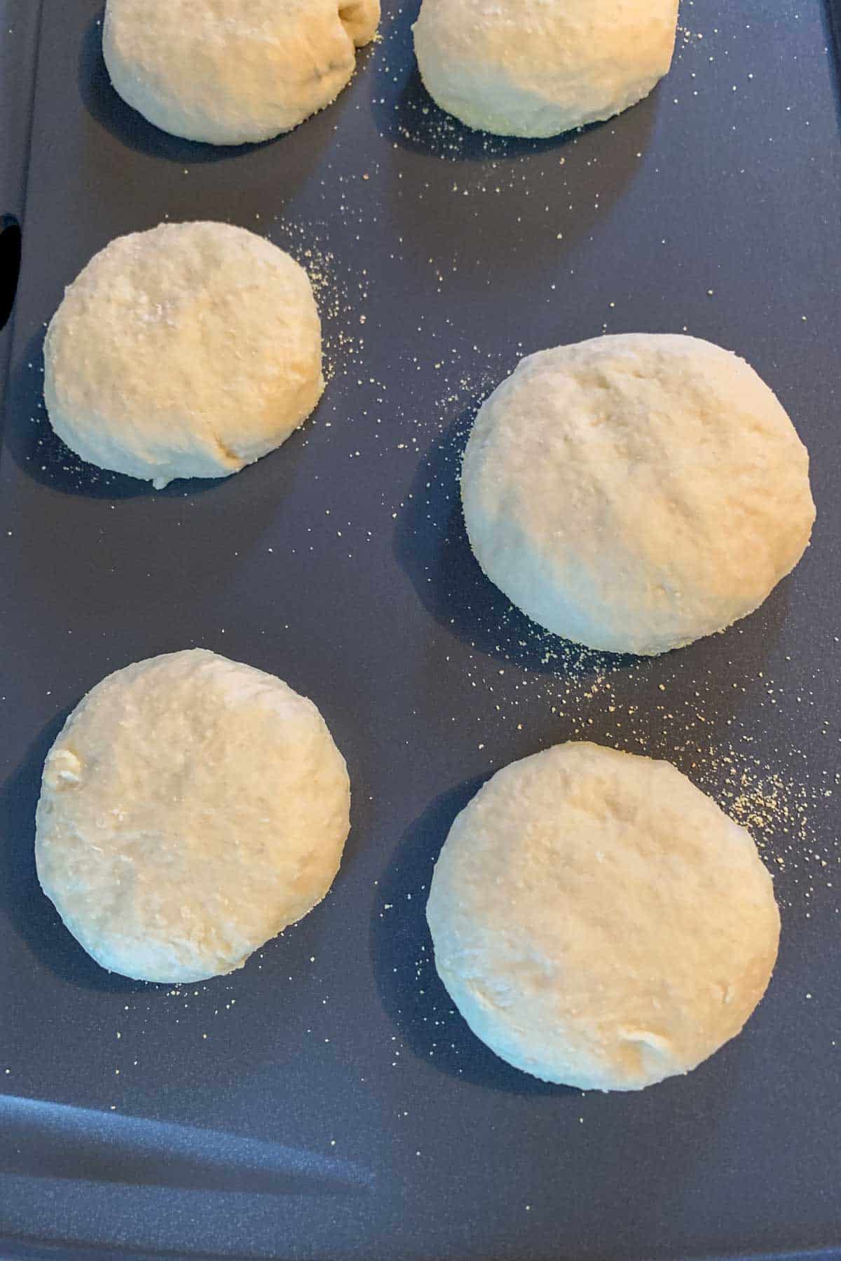 Unbaked English muffins on a griddle.