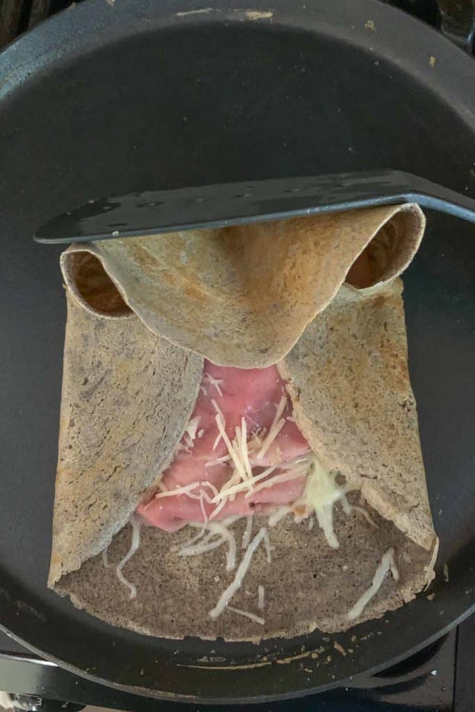 Folding a crepe edge over for a savory filled crepe.