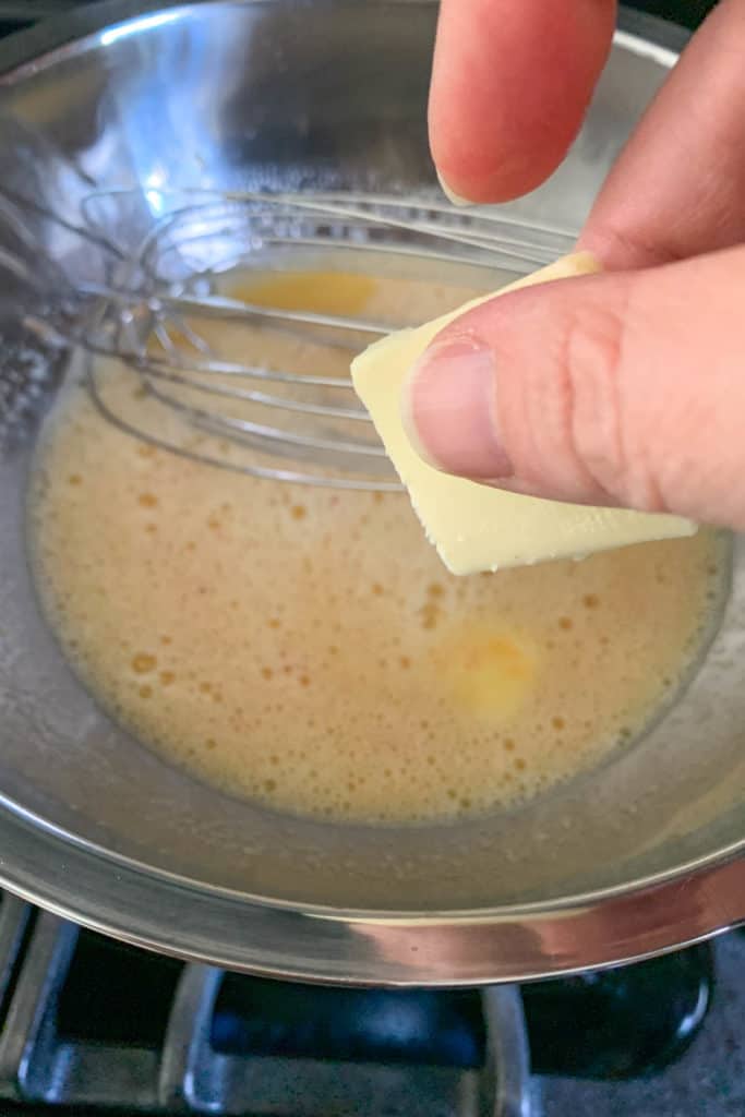 Adding butter piece to grapefruit curd.