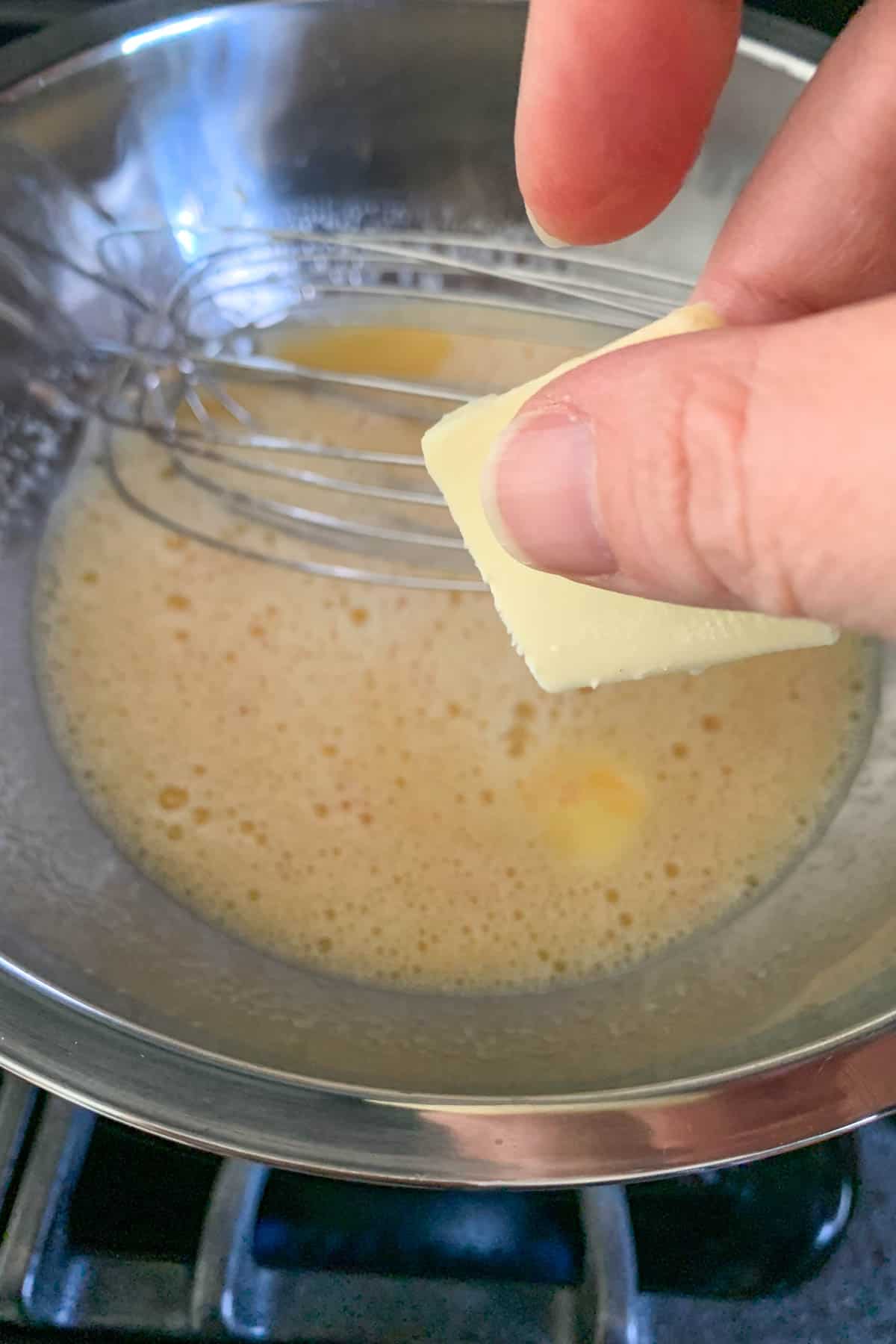 Adding butter piece to grapefruit curd.