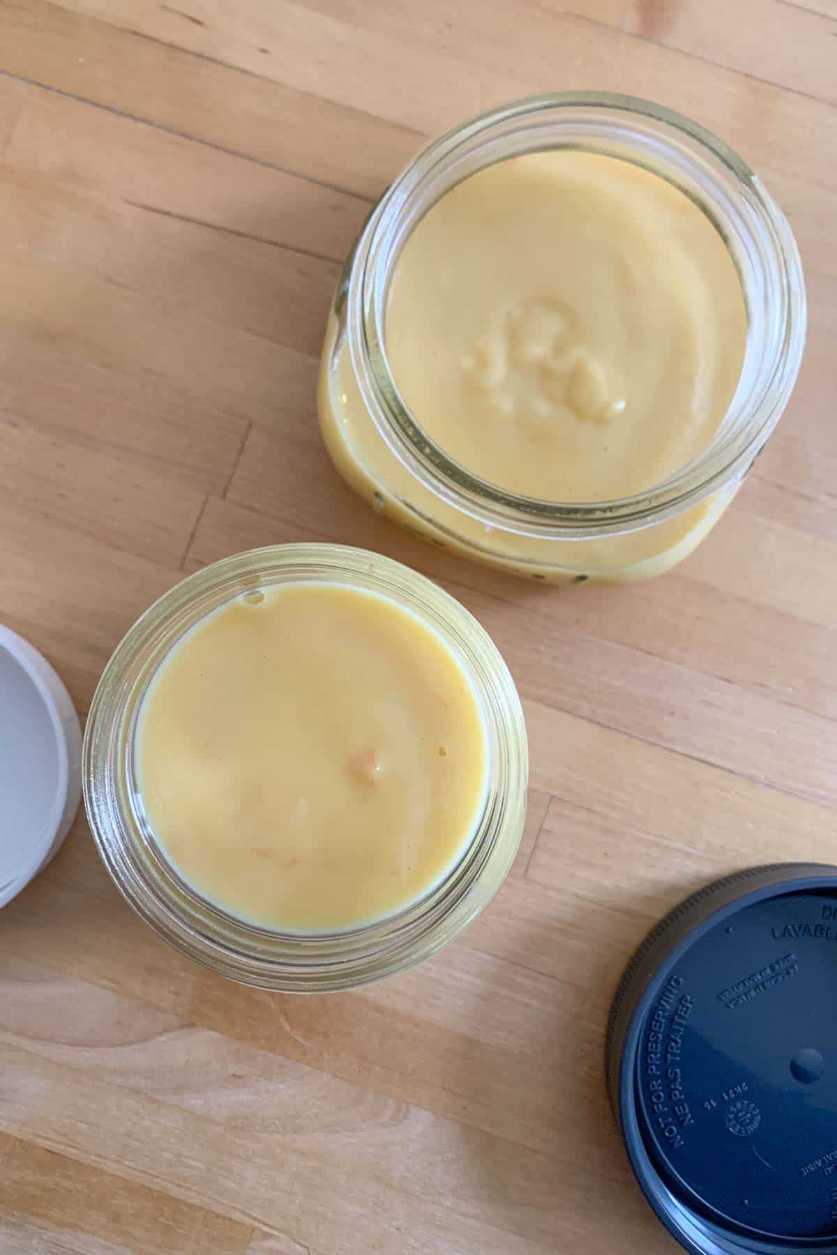 Grapefruit curd in jars on a wooden counter.