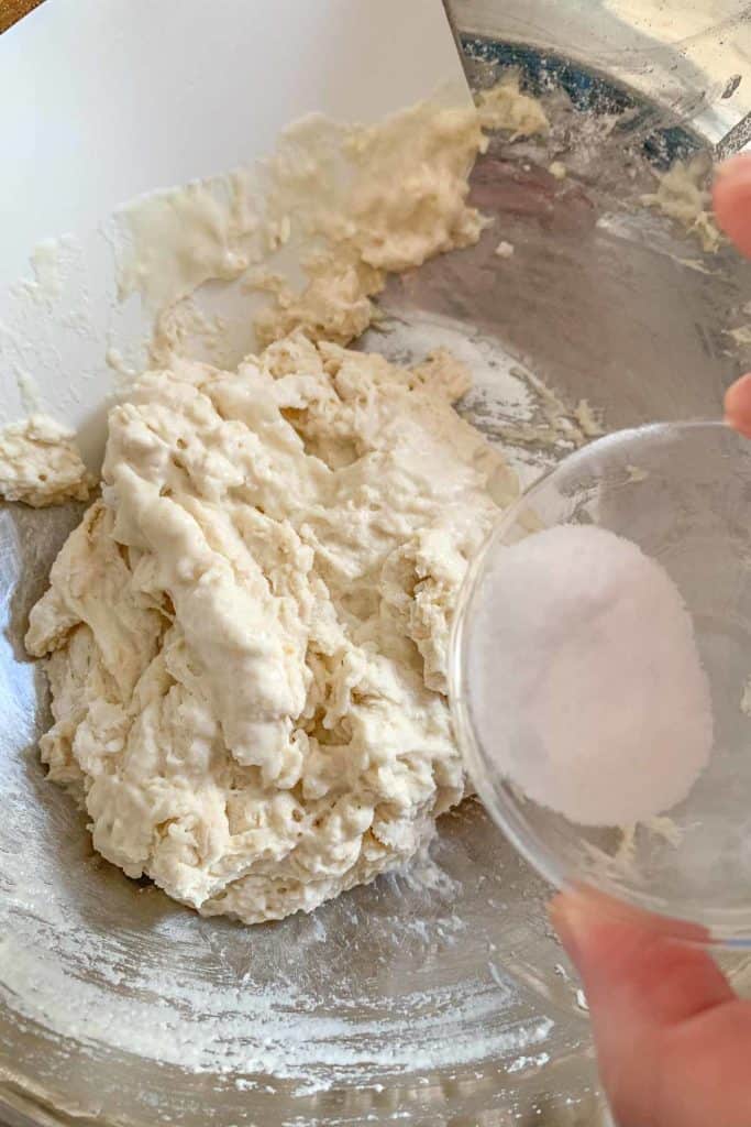 Adding salt to pizza dough.