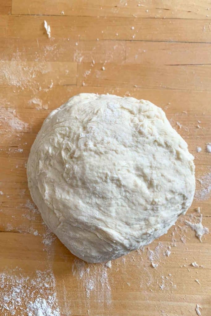 Unrisen pizza dough on a countertop.