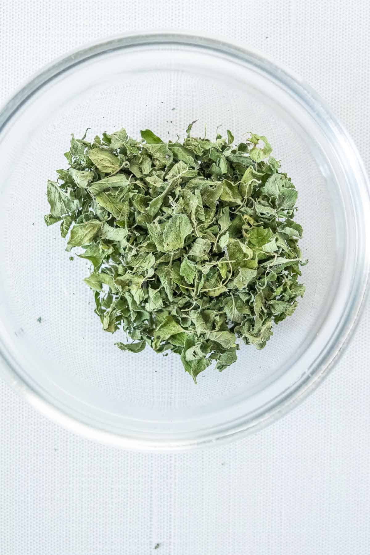 Dried oregano in a glass bowl.