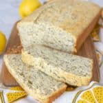 Sliced lemon poppy seed bread on a cutting board with a lemon printed napkin.