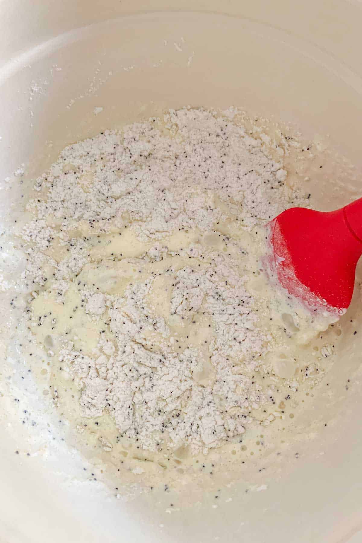 Bowl of ingredients for lemon poppy seed bread being mixed together.