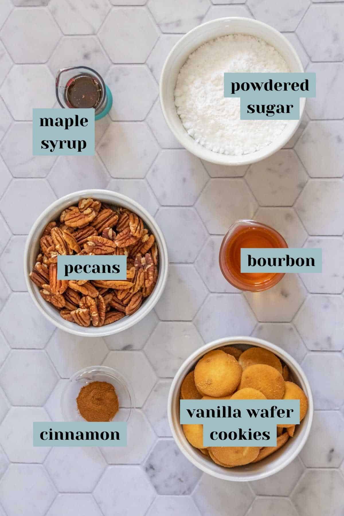 Ingredients for bourbon balls on a tile surface with labels.