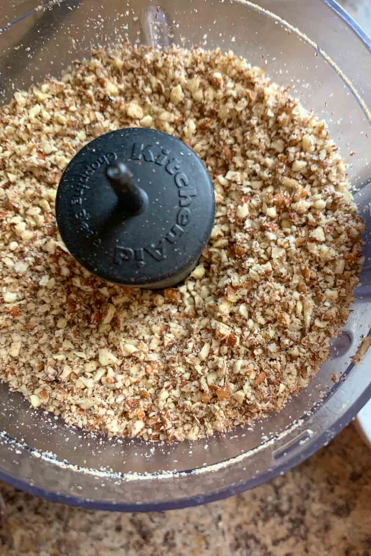 Chopped pecans in a small food processor.