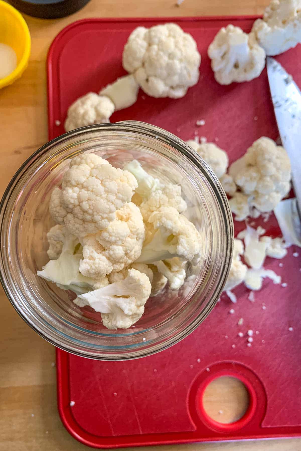 Jar filled with cauliflower pieces for pickling.