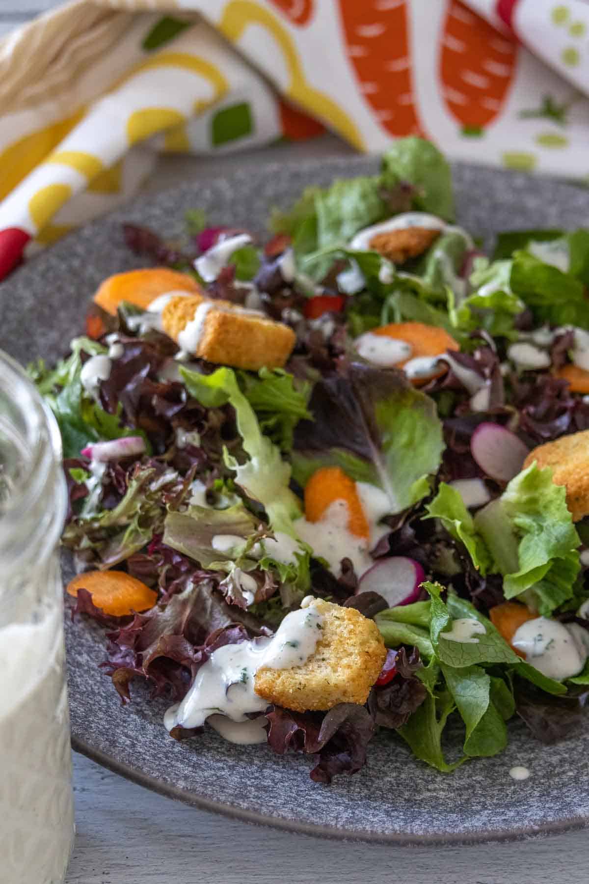 Salad with ranch dressing on a plate.