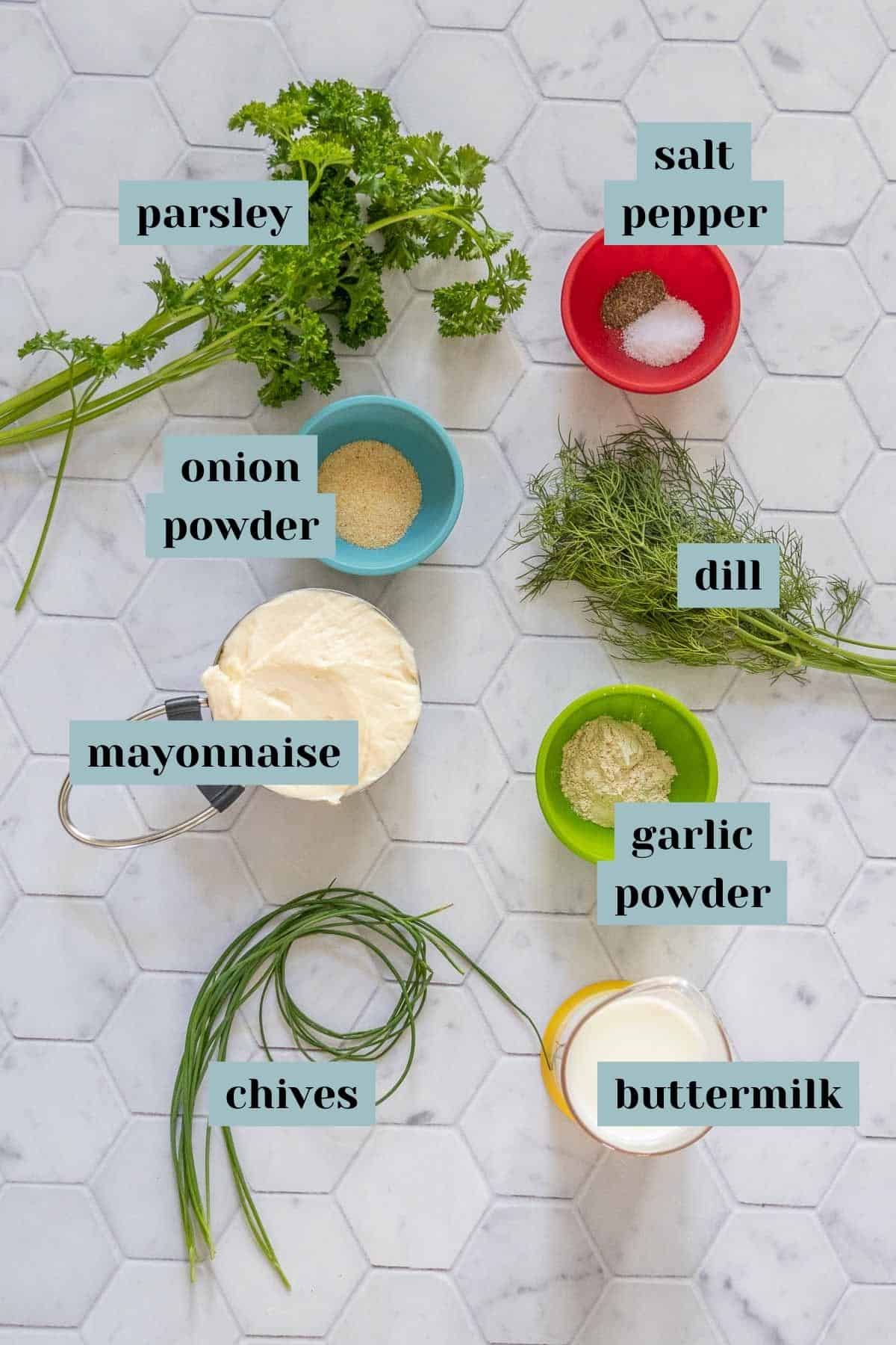 Ingredients for ranch dressing on a tile surface with labels.