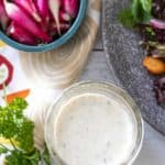 Overhead photo of ranch dressing in a jar with salad ingredients nearby.