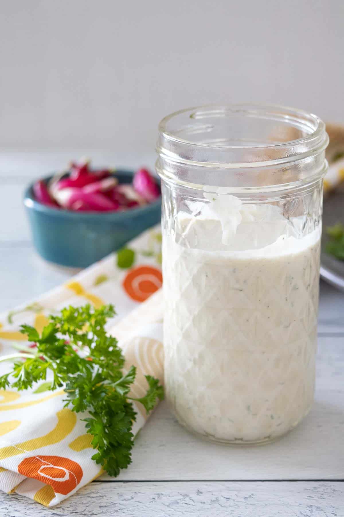 Glass jar filled with ranch dressing.