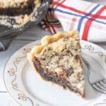 Slice of shoofly pie on a white plate with a fork beside.