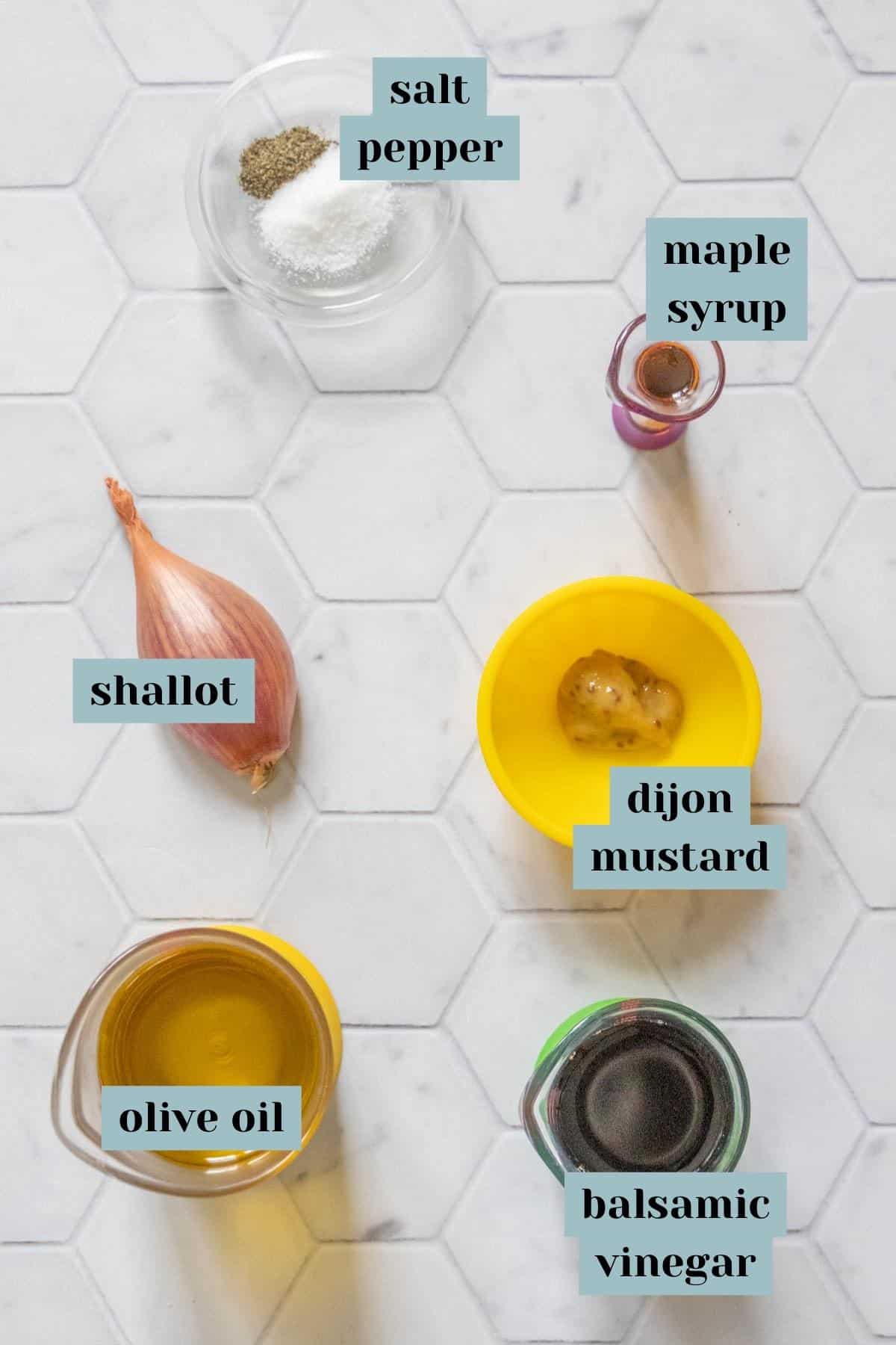 Ingredients for balsamic vinaigrette on a tile surface with labels.
